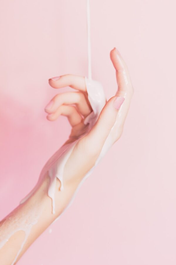 Photo by ian dooley a woman's hand holding a bottle of lotion